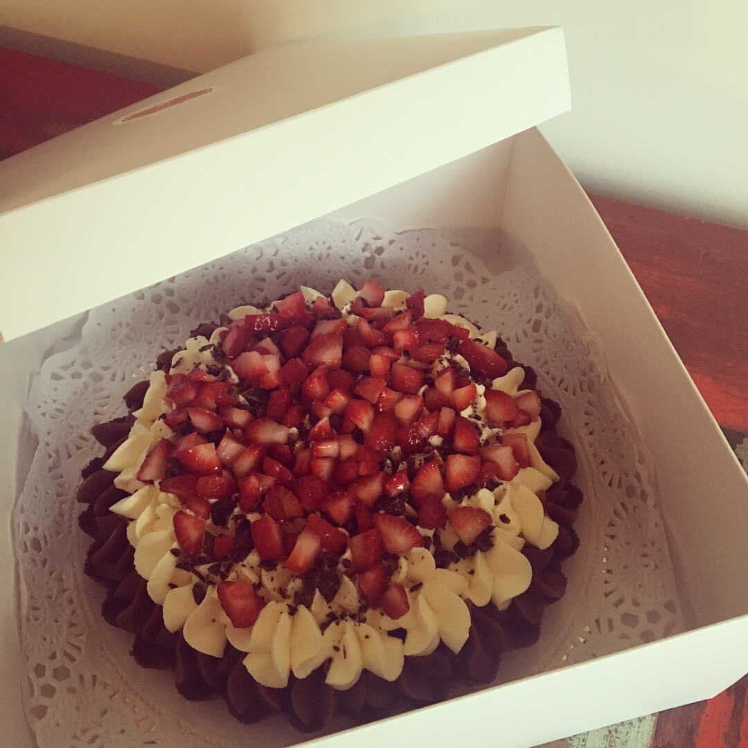 Torta de chocolate, crema y frutillas